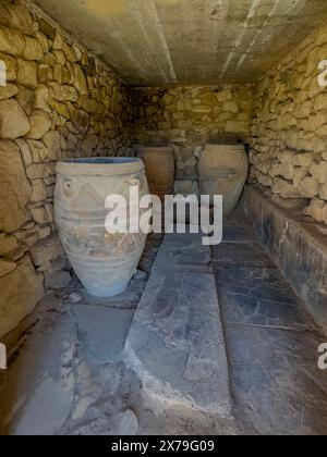 View into historical storeroom below present floor level with three large decorated clay vessels Pithoi in ancient magazine building with supplies in Stock Photo