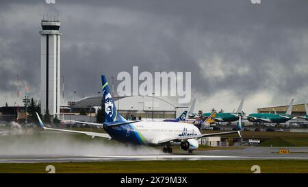 Everett, WA, USA - February 21, 2024; Alaska Airlines Boeing 737 900 ER taking off on runway in bad wet weather Stock Photo