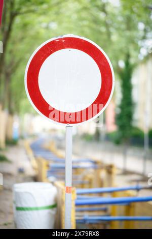A round white and red sign with the meaning 'no through traffic' at a road construction site in a residential neighbourhood Stock Photo
