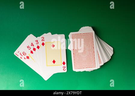 Salvador, Bahia, Brazil - May 10, 2024: Playing cards isolated on green background. Gambling. Stock Photo