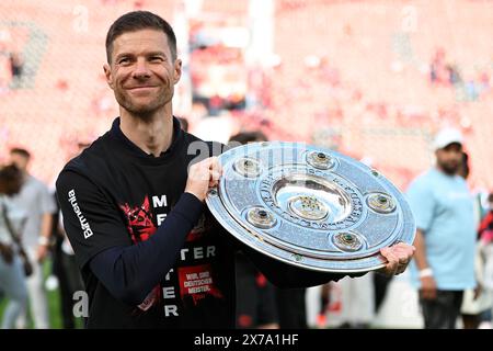 Leverkusen, Germany. 18th May, 2024. Xabi Alonso, head coach of Bayer 04 Leverkusen, holds the trophy during the celebration for winning the title of German first division Bundesliga in Leverkusen, Germany, May 18, 2024. Credit: Ulrich Hufnagel/Xinhua/Alamy Live News Stock Photo