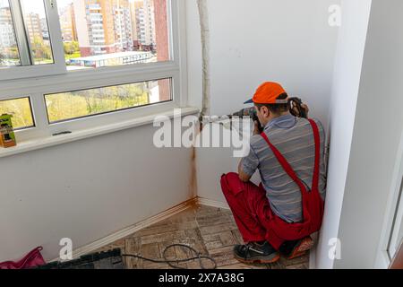 air conditioning system men is working drilling a wall Lviv Ukraine 08.04.2024 Stock Photo