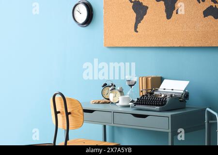 Vintage typewriter with coffee cup, alarm clocks and books on table in office Stock Photo