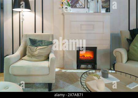 Warm and inviting living room featuring a comfortable sofa and a charming fireplace Stock Photo