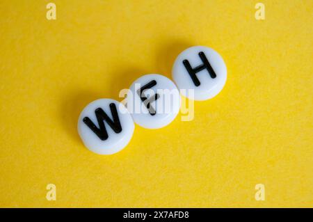 Top view of WFH text representing work from home on yellow background Stock Photo