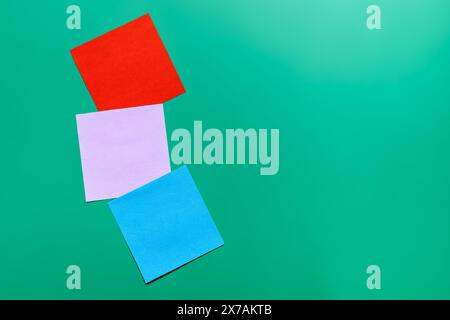 Stack of sticky notes on solid yellow background with green, blue, lilac, red Stock Photo