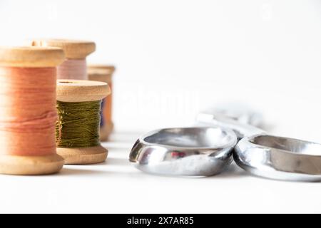 Threads on wooden old cats and sewing scissors on a white background, sewing, fashion and style Stock Photo