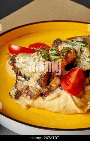 Veal ribs with peanut puree, mushroom sauce and cherry tomatoes Stock Photo