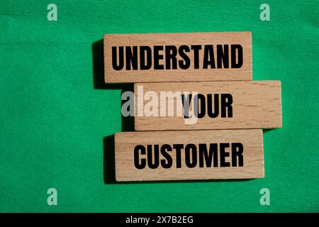 Understand your customer written on wooden blocks with green background. Conceptual understand your customer symbol. Copy space. Stock Photo