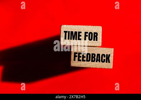 Time for feedback words written on wooden blocks with red background. Conceptual time for feedback symbol. Copy space. Stock Photo