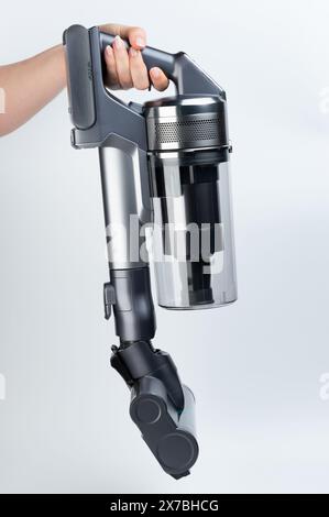 Portable mini vacuum cleaner in hand side view with carpet sweep brush Stock Photo