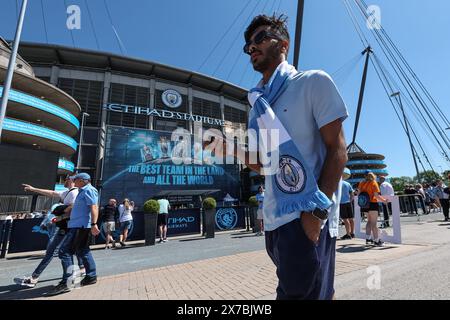 Man City fans arrive at the Etihad Stadium with the sun shining and clear blue skies during the Premier League match Manchester City vs West Ham United at Etihad Stadium, Manchester, United Kingdom, 19th May 2024  (Photo by Mark Cosgrove/News Images) Stock Photo