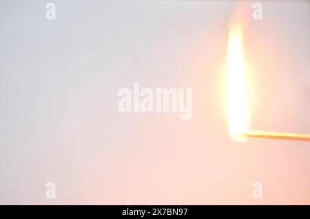red head matchstick lighting on in white background Stock Photo