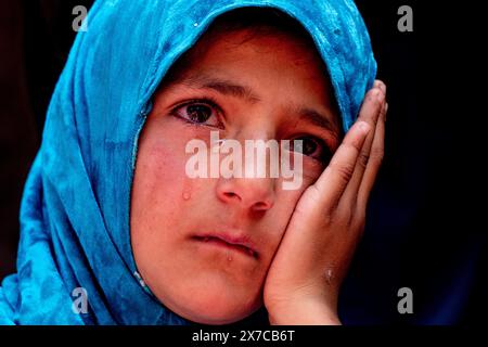 A Kashmiri girl weeps near the dead body of slain former sarpanch or village head Aijaz Sheikh during his funeral procession after suspected militants fired upon him at his home last night in Heerpora Shopian, south of Srinagar. A former sarpanch or village head was slain and an Indian tourist couple injured in two separate militant strikes in Shopian and Anantnag last night, ahead of the Baramulla parliamentary constituency elections in Jammu and Kashmir. Stock Photo