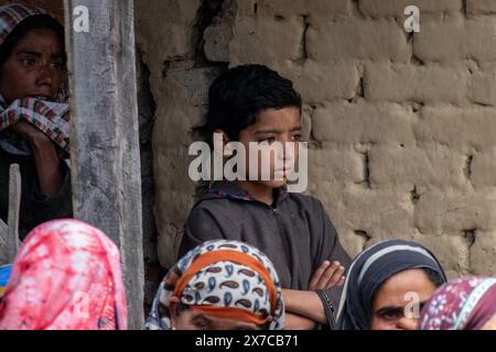 A Kashmiri boy looks towards the dead body of slain former sarpanch or village head Aijaz Sheikh during his funeral procession after suspected militants fired upon him at his home last night in Heerpora Shopian, south of Srinagar. A former sarpanch or village head was slain and an Indian tourist couple injured in two separate militant strikes in Shopian and Anantnag last night, ahead of the Baramulla parliamentary constituency elections in Jammu and Kashmir. Stock Photo