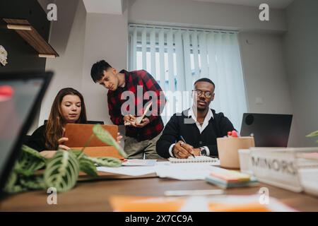 Multiracial team of young business professionals working on a project in a modern office Stock Photo