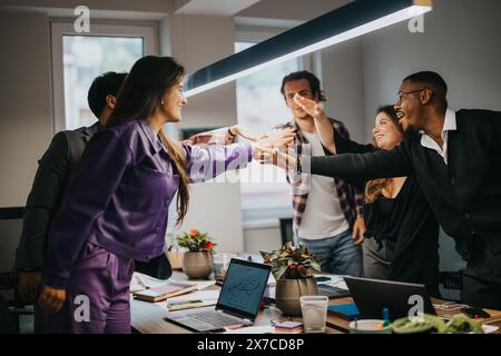 Energetic business team celebrates a successful meeting in a modern office Stock Photo