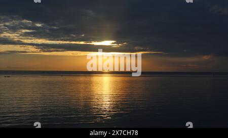 the atmosphere of the sunrise at the end of the sea with the beautiful reflection of the sun in the sea water Stock Photo