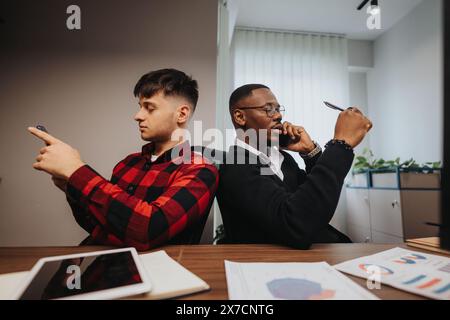Young professionals using smart phones during a business meeting in a modern office Stock Photo
