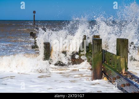 Waves crashing against a wooden groyne in Trimingham, North Norfolk, UK Stock Photo