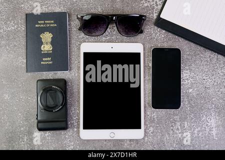 This stock photo showcases a flat lay arrangement of travel must-haves, including a tablet, passport, sunglasses, and a smartphone Stock Photo