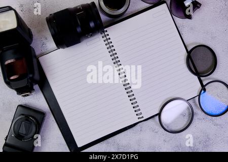 This image is about Blank notepad with camera and lenses on a white background. Stock Photo