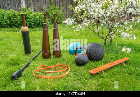 fitness equipment on green lawn in springtime scenery, backyard gym concept Stock Photo