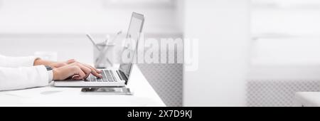Unrecognizable lady working on her laptop at office Stock Photo