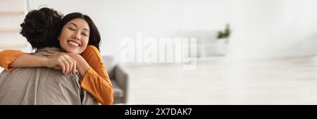 Young Asian lady hugging her husband and holding house key Stock Photo