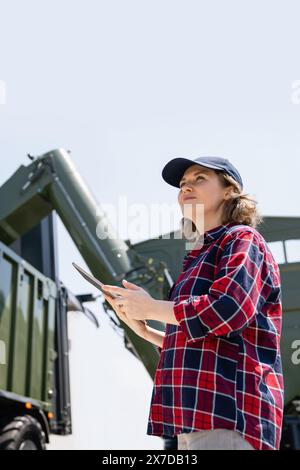 Woman farmer with tablet watching grain loading Stock Photo