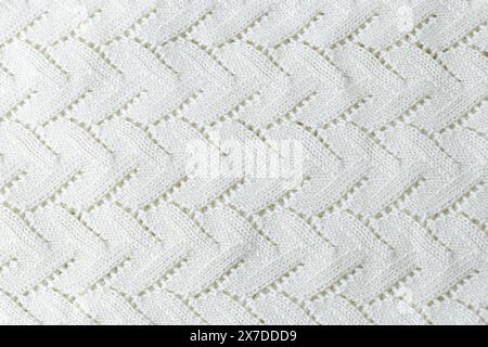 A white knit blanket with a zigzag pattern. Repetitive abstract pattern. Stock Photo