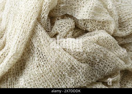 A white fabric with a pattern of holes. The fabric is knitted and has a fuzzy texture Stock Photo