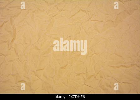 Beige color background with dense wrinkles. Beige color recycled kraft paper texture as background. Stock Photo