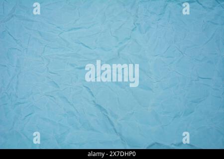Light blue background with dense wrinkles. Light blue color recycled kraft paper texture as background. Stock Photo