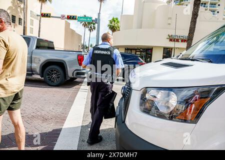 Miami Beach Florida,Collins Avenue,Brinks armored truck van,armed guard,Black African man weapon gun,carrying money bag,wearing bulletproof vest,dange Stock Photo