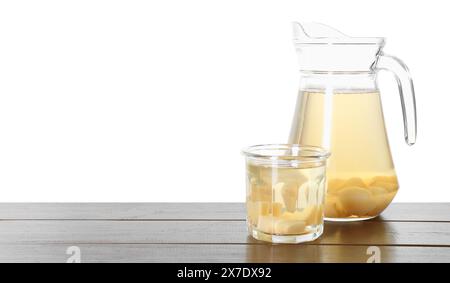 Delicious quince drink in jug and glass on wooden table against white background Stock Photo