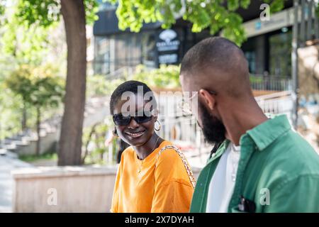 Loving happy black couple met on street for date sit smiling chatting enjoy attraction to each other Stock Photo