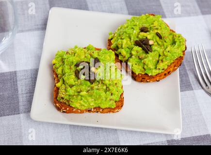Two whole grain toasts with guacamole and pumpkin seeds Stock Photo - Alamy