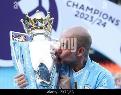 Manchester, UK. 20th May, 2024. Manchester City's manager Pep Guardiola kisses the Premier League trophy after the English Premier League football match between Manchester City and West Ham United in Manchester, Britain, on May 19, 2024. Credit: Xinhua/Alamy Live News Stock Photo