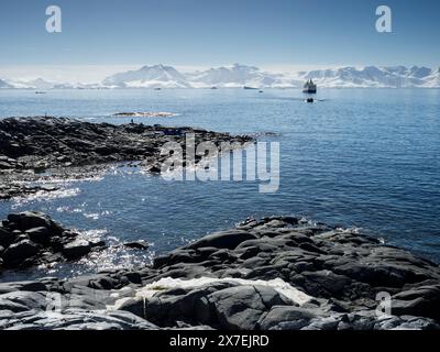 Tourist cruise ship disembarking passengers on the rocky shore at Palaver Point, Two Hummock Island, Antarctica Stock Photo