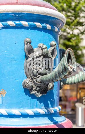 Close-up detail of medieval fountain with face spouting water from a shell-like horn, Lucerne, Switzerland, 16 Aug 2022. Stock Photo