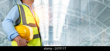 Civil engineer architect standing holding a safety helmet on construction site background, Construction site plans to build high-rise buildings, Engin Stock Photo