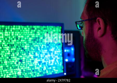 A person analyzing code on a screen, engaged in hacking activities Stock Photo