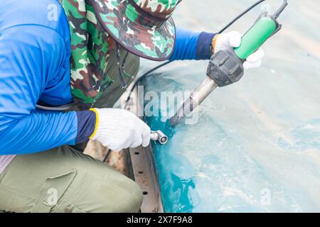 Hot-wedge welding patch canvas and stainless roller compress plastic canvas on waster water treatment dome. Stock Photo