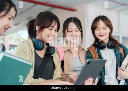 students enjoying working together, collaborating on project. asian students discussing notes outdoors on campus Stock Photo