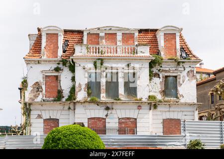 Abandoned hostal Palas overgrown with plants. Old architecture in Bilbao Stock Photo