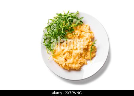 Scrambled eggs with arugula salad on white plate isolated on white background, top view. Healthy keto breakfast - fresh scrambled eggs, design element Stock Photo