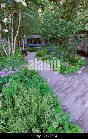 London, UK. 20th May, 2024. Opening day at the 2024 Royal Horticultural Society Chelsea Flower Show - one of the Show Gardens on display: the Muscular Dystrophy UK - Forest Bathing Garden.  The Forest Bathing Garden is a sanctuary for those with muscle-wasting conditions. Inspired by Shinrin-yoku, it offers refuge to patients, families, and clinicians. A flint wall, resembling muscle cells, helps explain muscular dystrophy. At its core is a sheltered hub for meeting and sharing experiences, bridging the gap between people and nature. Credit: Michael Preston/Ģ����ý Live News Stock Photo