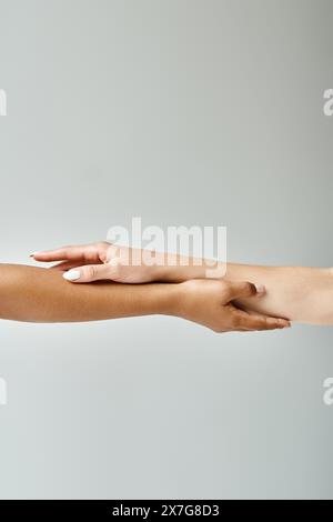 Two beautiful diverse women reaching out towards each other. Stock Photo