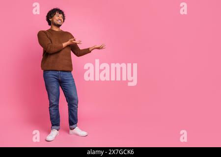 Photo of good mood positive man wear trendy brown clothes introduce empty space isolated on pink color background Stock Photo